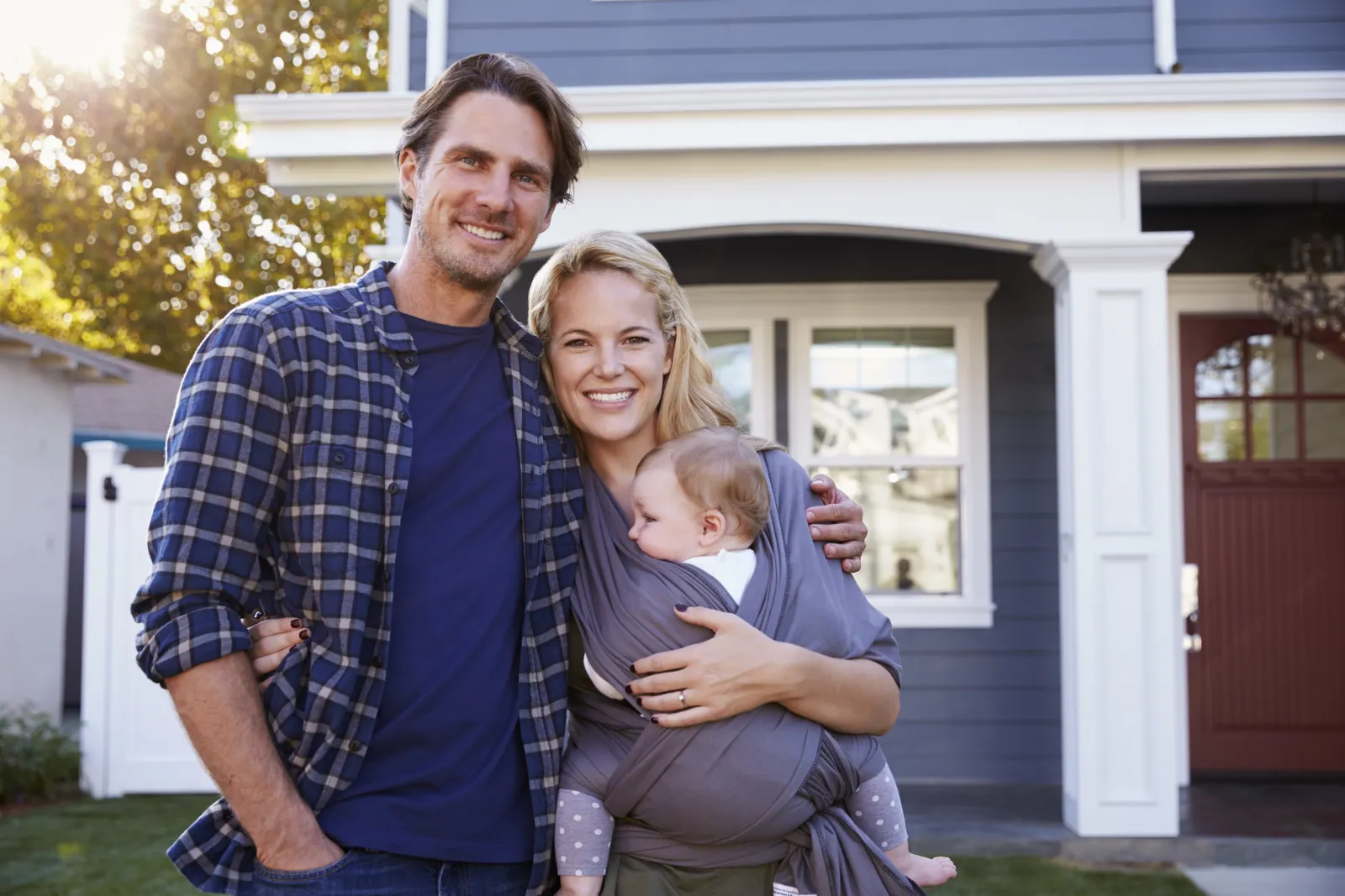 parents and baby outside of house