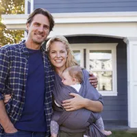 parents and baby outside of house